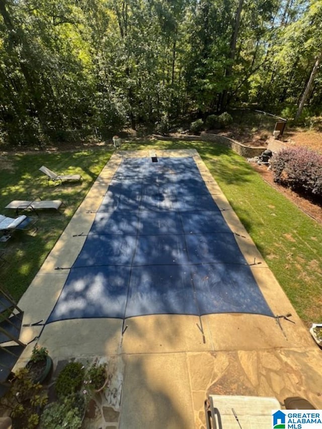 view of swimming pool with a lawn