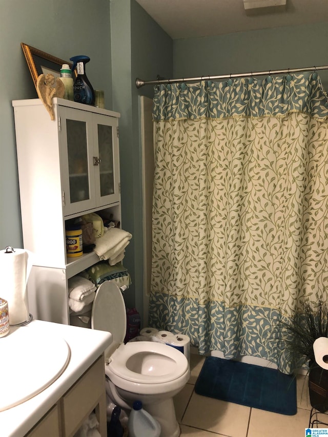 bathroom featuring curtained shower, vanity, toilet, and tile patterned floors