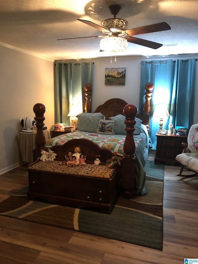 bedroom featuring a textured ceiling, crown molding, hardwood / wood-style floors, and ceiling fan