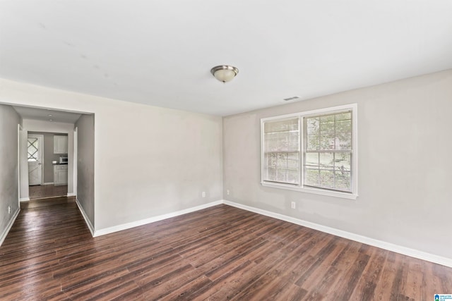 spare room featuring dark wood-type flooring