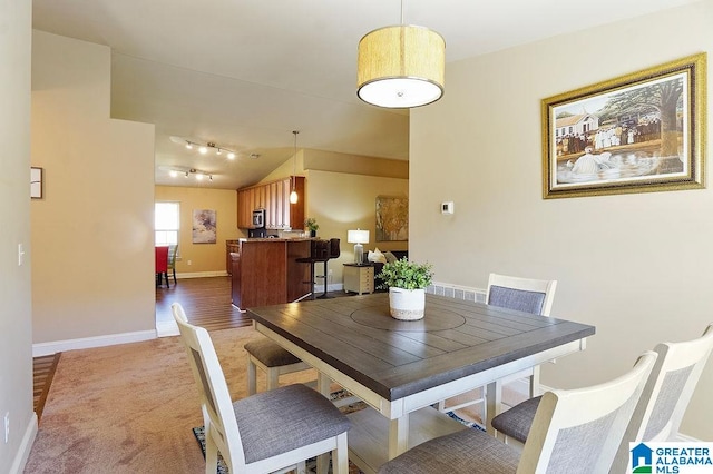 dining room featuring light hardwood / wood-style flooring and lofted ceiling