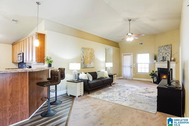 carpeted living room featuring high vaulted ceiling and ceiling fan