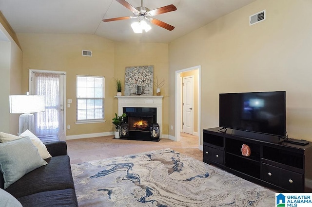 carpeted living room with ceiling fan and lofted ceiling