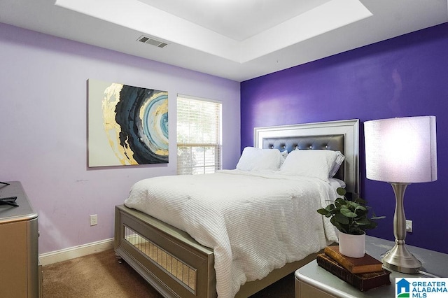 carpeted bedroom with a tray ceiling