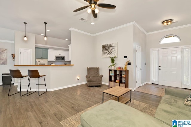 entryway with ceiling fan, hardwood / wood-style floors, and crown molding