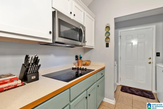 kitchen featuring white cabinetry, light tile patterned floors, and black electric cooktop