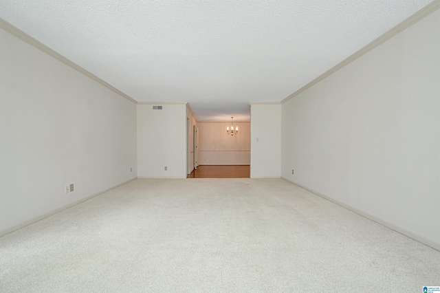 carpeted spare room featuring an inviting chandelier, a textured ceiling, and crown molding