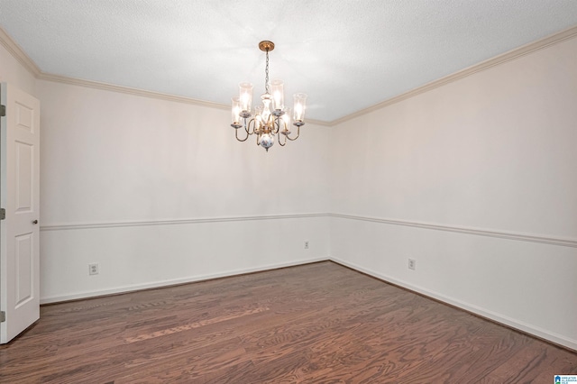 spare room with a textured ceiling, ornamental molding, dark hardwood / wood-style floors, and a notable chandelier