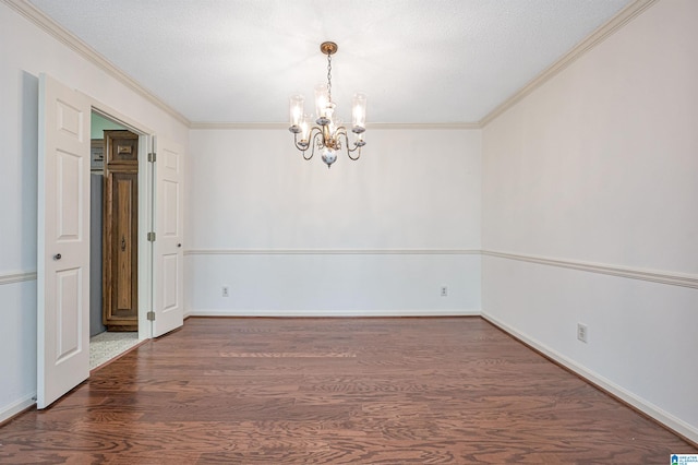 spare room featuring ornamental molding, an inviting chandelier, dark hardwood / wood-style flooring, and a textured ceiling