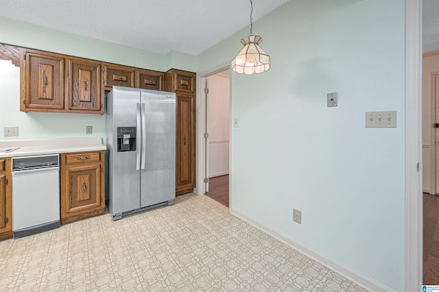 kitchen featuring pendant lighting and stainless steel fridge with ice dispenser