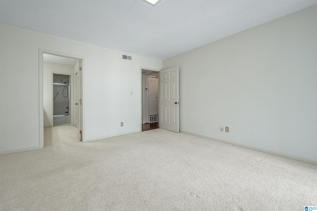 unfurnished bedroom with a textured ceiling and light colored carpet