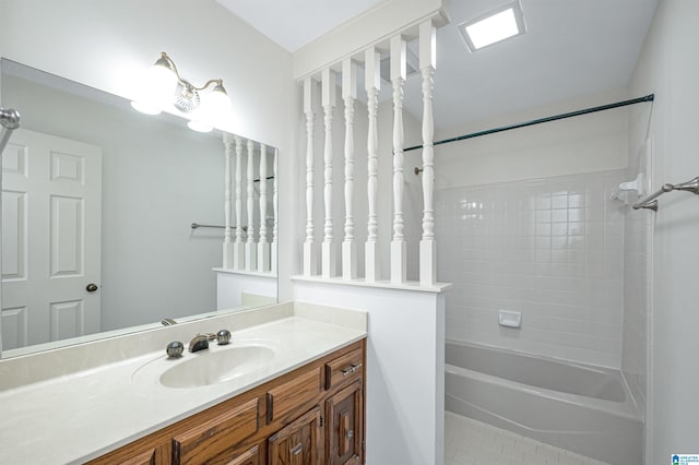 bathroom featuring tile patterned floors, tiled shower / bath, and vanity