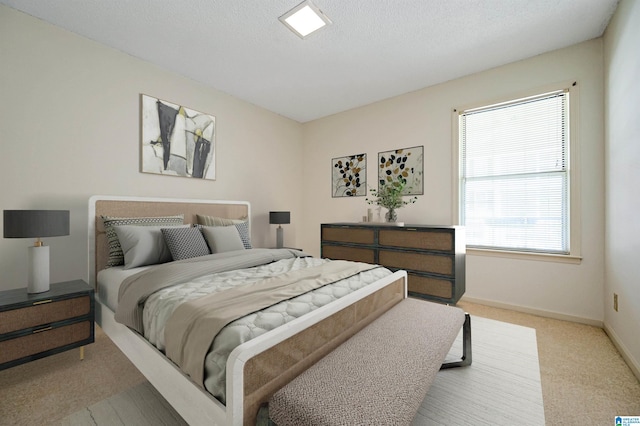 bedroom with a textured ceiling and light carpet