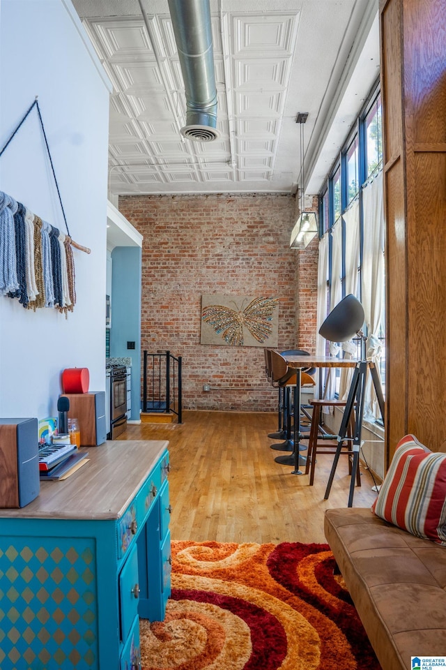 interior space with light wood-type flooring and brick wall