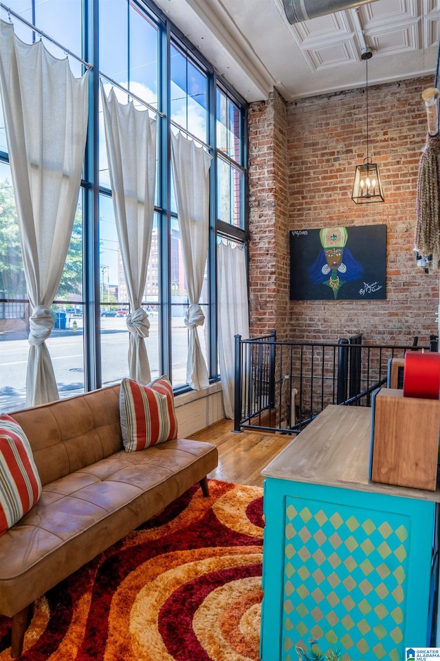 living room with brick wall and hardwood / wood-style flooring