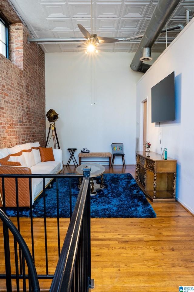 bedroom featuring wood-type flooring and brick wall