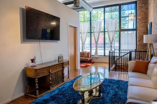 living room with wood-type flooring and brick wall