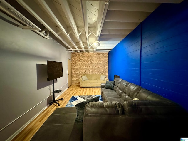 cinema room with brick wall and hardwood / wood-style floors