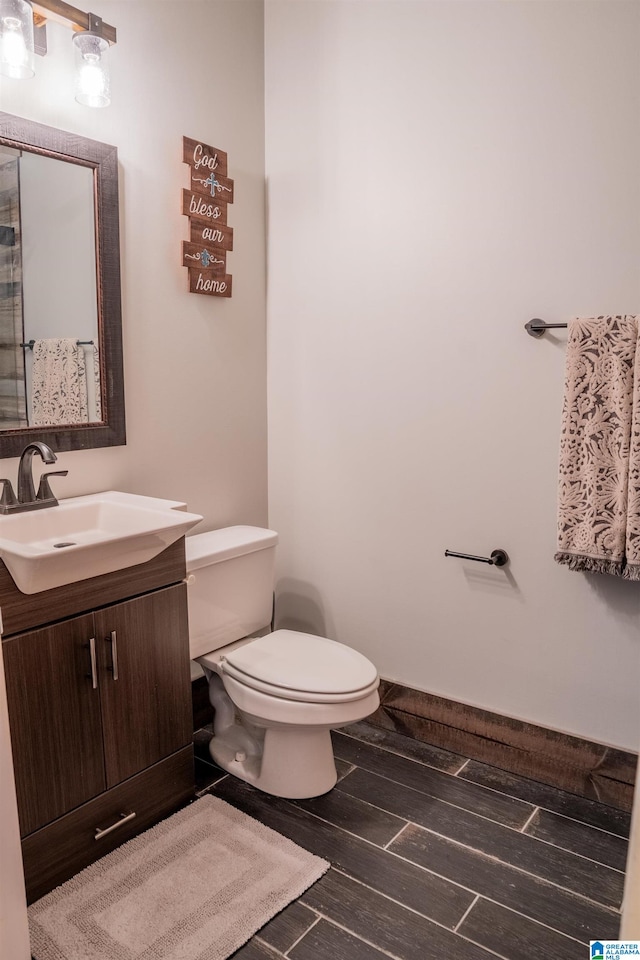 bathroom featuring vanity, hardwood / wood-style flooring, and toilet