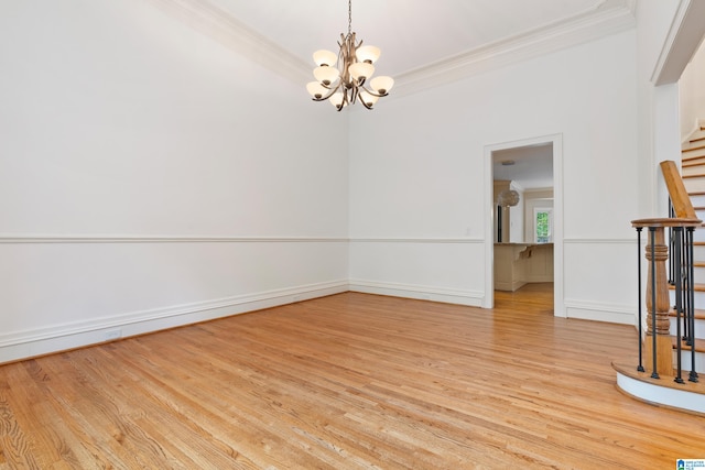 unfurnished room featuring a notable chandelier, light hardwood / wood-style flooring, and crown molding