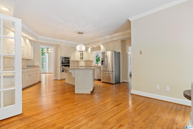 kitchen featuring decorative light fixtures, appliances with stainless steel finishes, a center island, an inviting chandelier, and light hardwood / wood-style floors