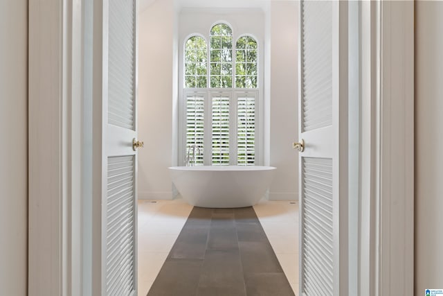 bathroom with tile patterned flooring and a tub to relax in