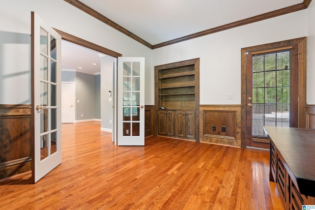 interior space with light hardwood / wood-style flooring, french doors, and crown molding