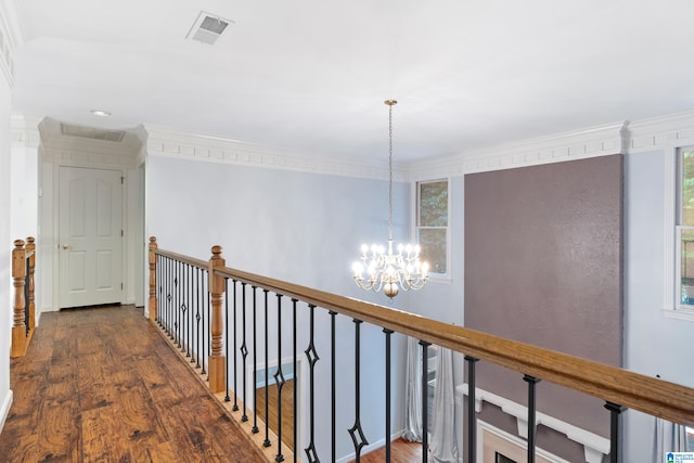 corridor with dark hardwood / wood-style floors, a chandelier, and crown molding