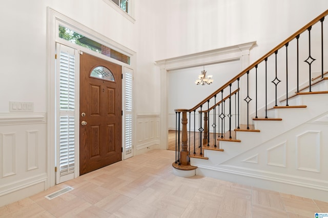 entryway with a high ceiling and an inviting chandelier