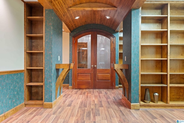 foyer entrance with lofted ceiling, hardwood / wood-style floors, wooden ceiling, and french doors