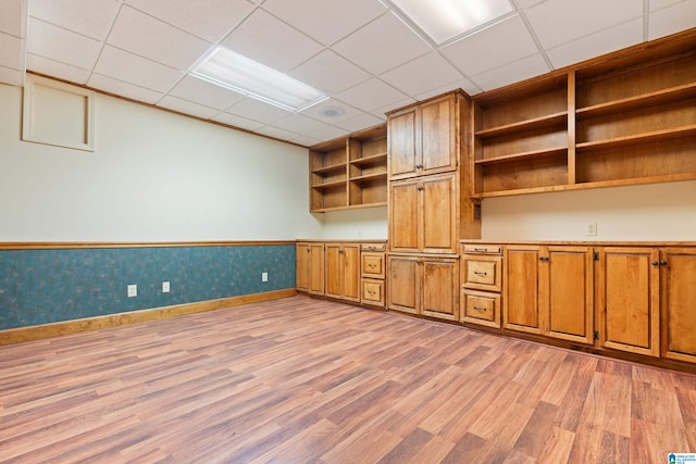 unfurnished office featuring light wood-type flooring and a paneled ceiling