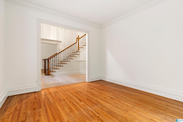 empty room with wood-type flooring and crown molding