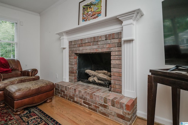 living room with a brick fireplace, hardwood / wood-style flooring, and ornamental molding