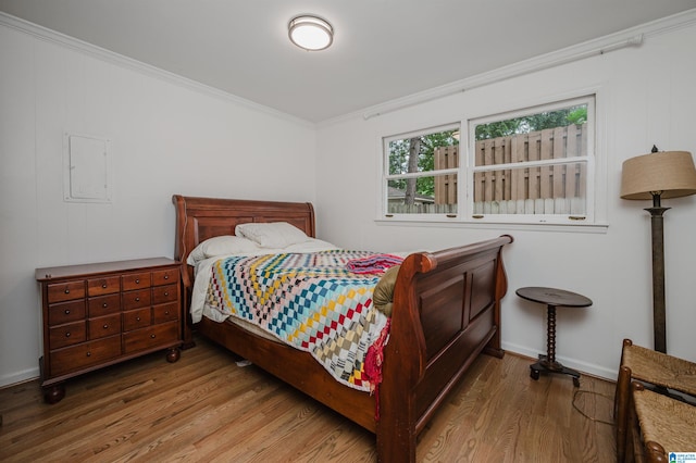 bedroom featuring wood-type flooring and crown molding