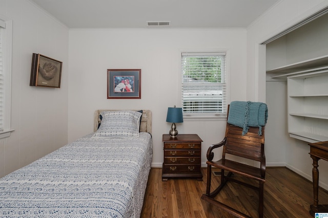 bedroom with ornamental molding, a closet, and dark hardwood / wood-style flooring