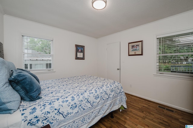 bedroom featuring ornamental molding and dark wood-type flooring