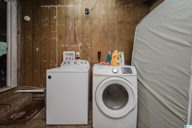 laundry area with wooden walls and washing machine and clothes dryer