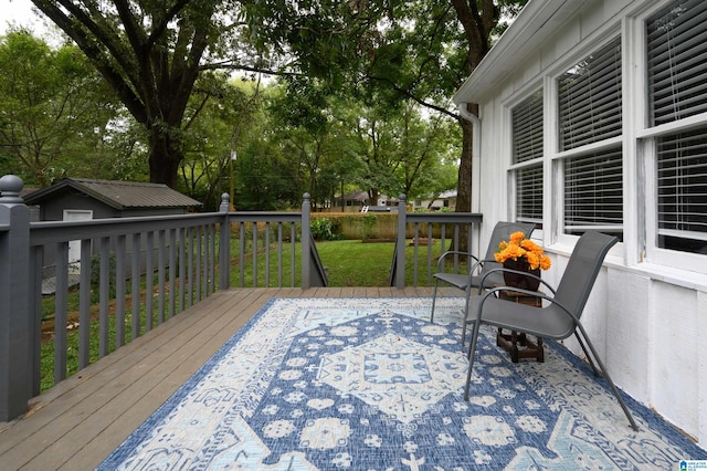 wooden deck featuring a yard and a storage unit