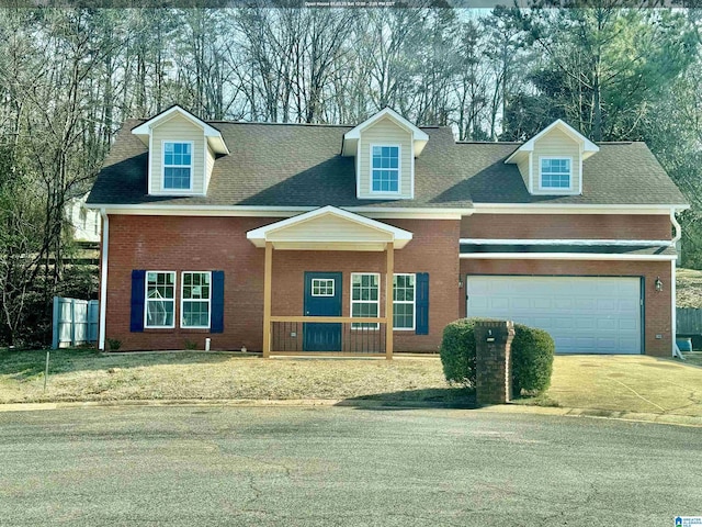 new england style home featuring a garage, brick siding, driveway, and roof with shingles