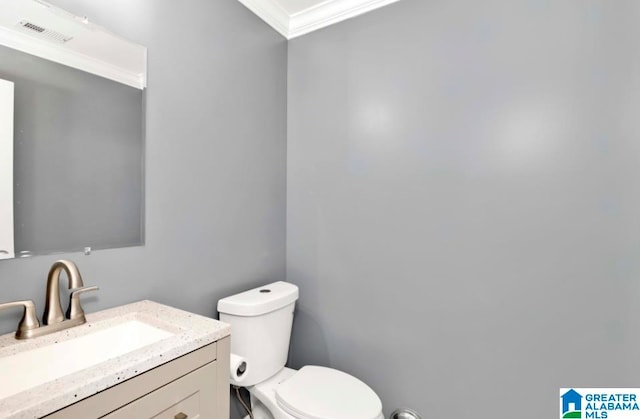 bathroom with vanity, crown molding, and toilet