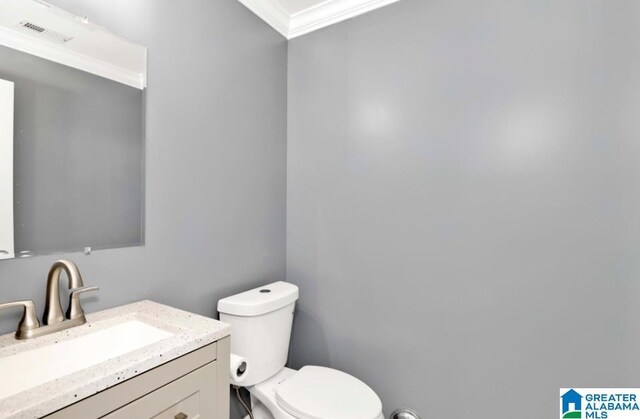 bathroom with ornamental molding, toilet, visible vents, and vanity