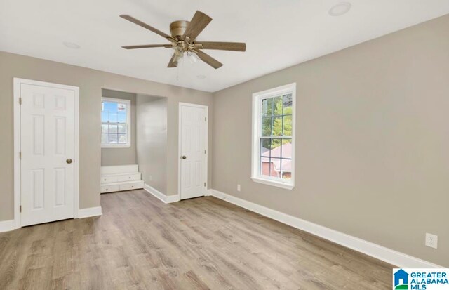 unfurnished bedroom with ceiling fan, light hardwood / wood-style flooring, and multiple windows