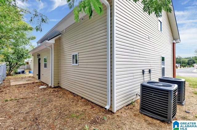 view of property exterior with fence and central AC unit