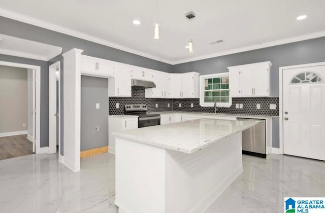 kitchen with pendant lighting, white cabinetry, a kitchen island, appliances with stainless steel finishes, and ornamental molding