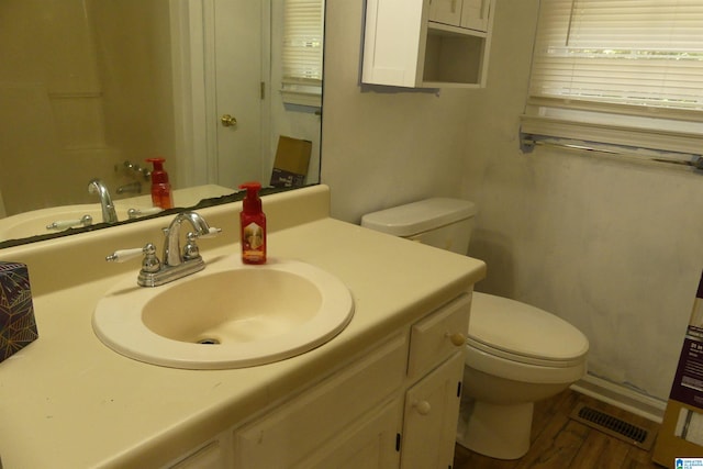 bathroom featuring wood-type flooring, vanity, and toilet