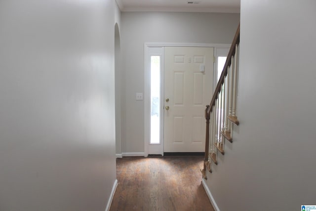 entryway featuring ornamental molding and dark wood-type flooring