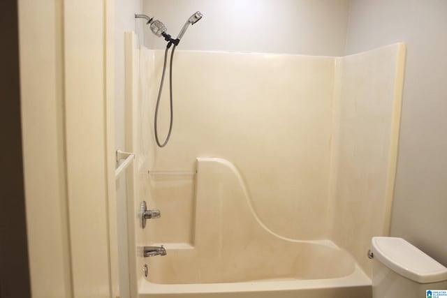 bathroom with bathtub / shower combination and toilet