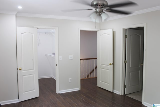 unfurnished bedroom with ceiling fan, a closet, dark hardwood / wood-style floors, and a spacious closet