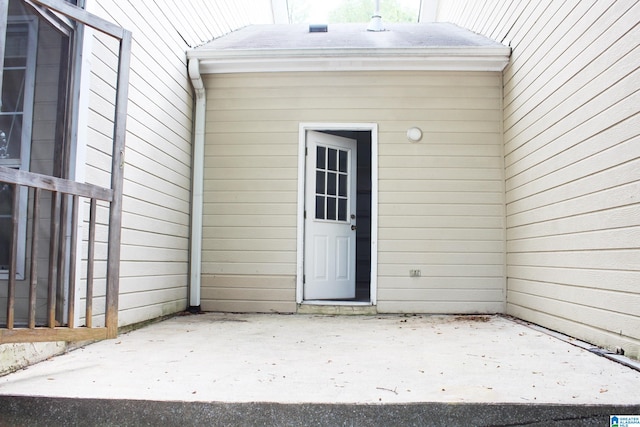 view of exterior entry with a patio area