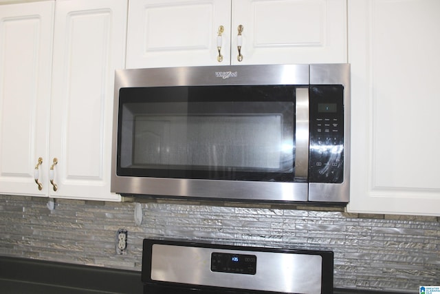 interior details featuring white cabinetry and tasteful backsplash